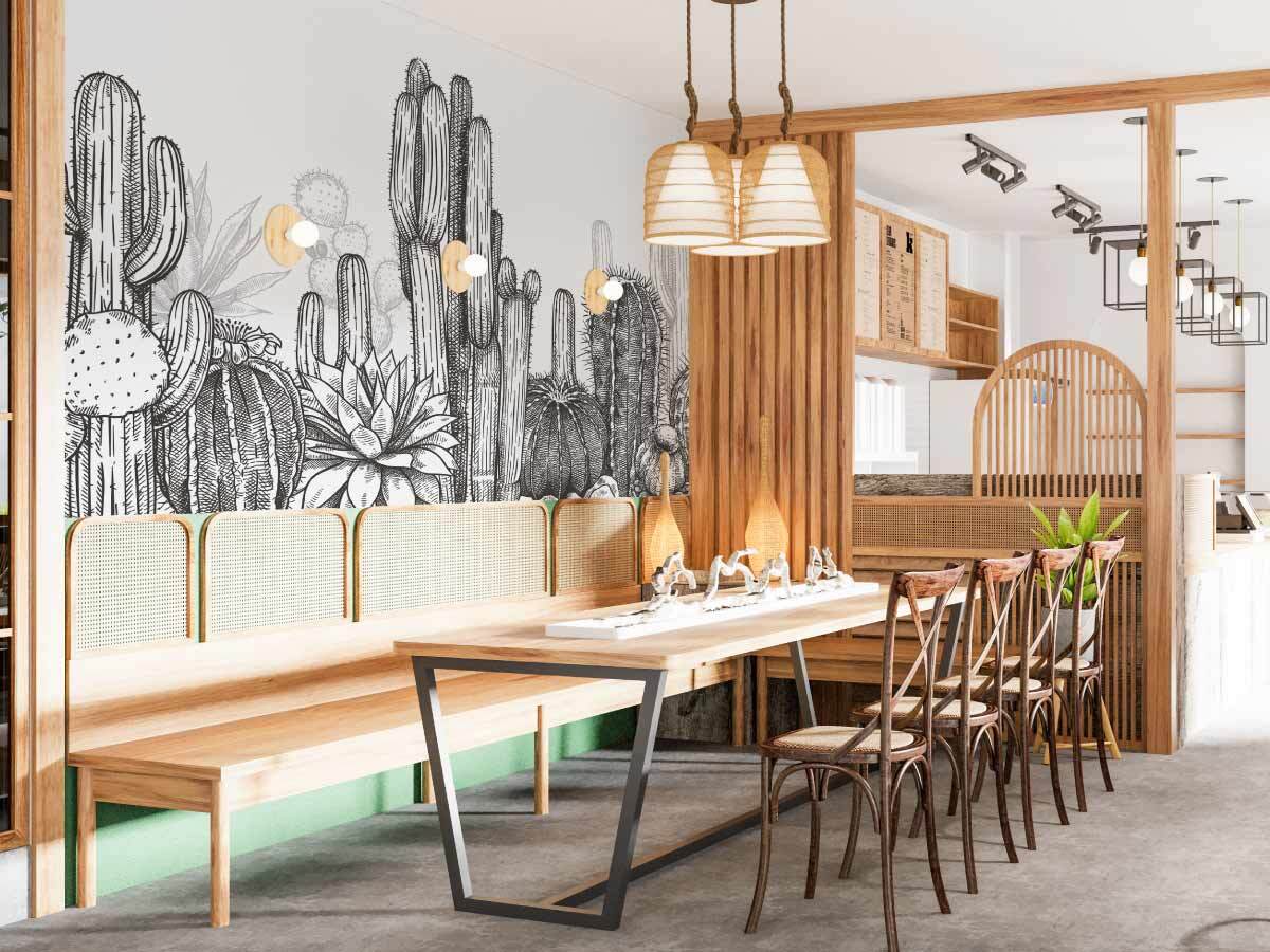 photo d'un restaurant avec papier peint style boheme avec meuble rotin en bois, et notre papier peint gravure cactus